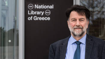 Filippos Tsiboglou, Director of the National Library of Greece, standing smiling at the entrance of the National Library of Greece